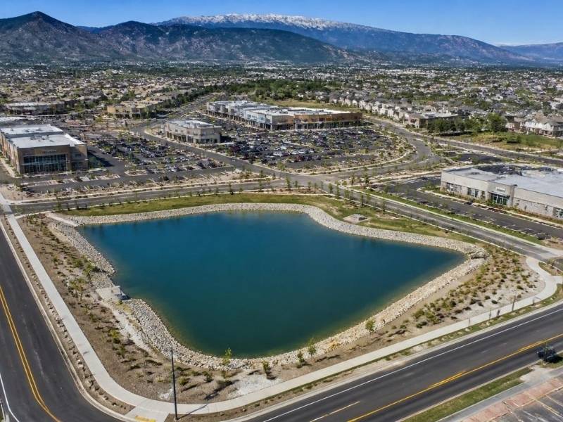 Aerial view of an engineered detention pond serving a commercial development for stormwater management in Colorado Springs, CO.